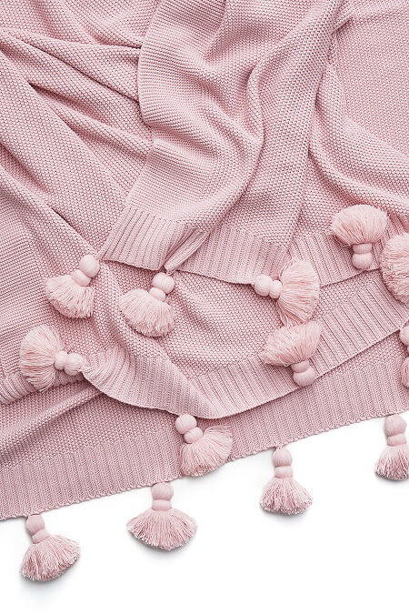 Jasnoróżowa narzuta z frędzlami w stylu boho